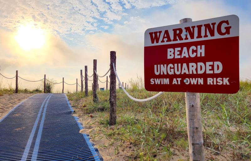 A sign posted at the beach entrance from Queen Street in Rehoboth Beach warns that this area is unguarded. Due in large part to the return of lifeguards to college, some sections of the city’s beaches are now unguarded, and beachgoers are urged to use the guarded areas as much as possible. CHRIS FLOOD PHOTO